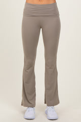 woman wearing light brown flared yoga pants with a wide waistband and white athletic shoes