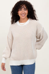 woman wearing a cream and beige striped oversized sweater with balloon sleeves and a relaxed fit
