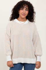 woman wearing a cream and beige striped oversized sweater with balloon sleeves and a ribbed hem