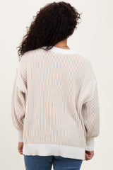 woman wearing a beige and cream striped oversized sweater, showing the back view and relaxed fit