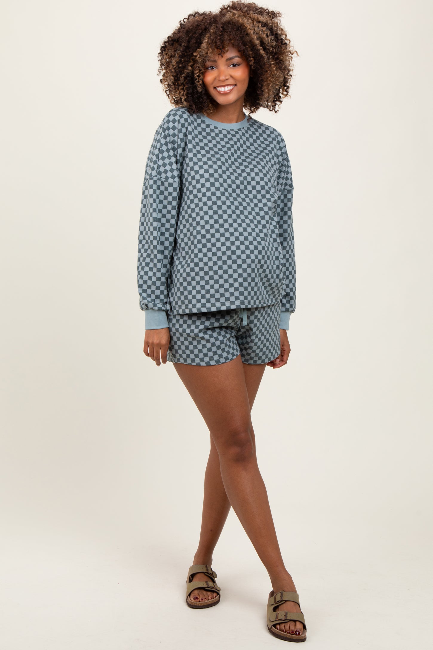 woman wearing a maternity light blue checkered lounge set consisting of a long sleeve top and shorts