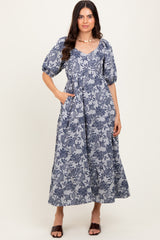 woman wearing a navy blue floral print maxi dress with puff sleeves and pockets