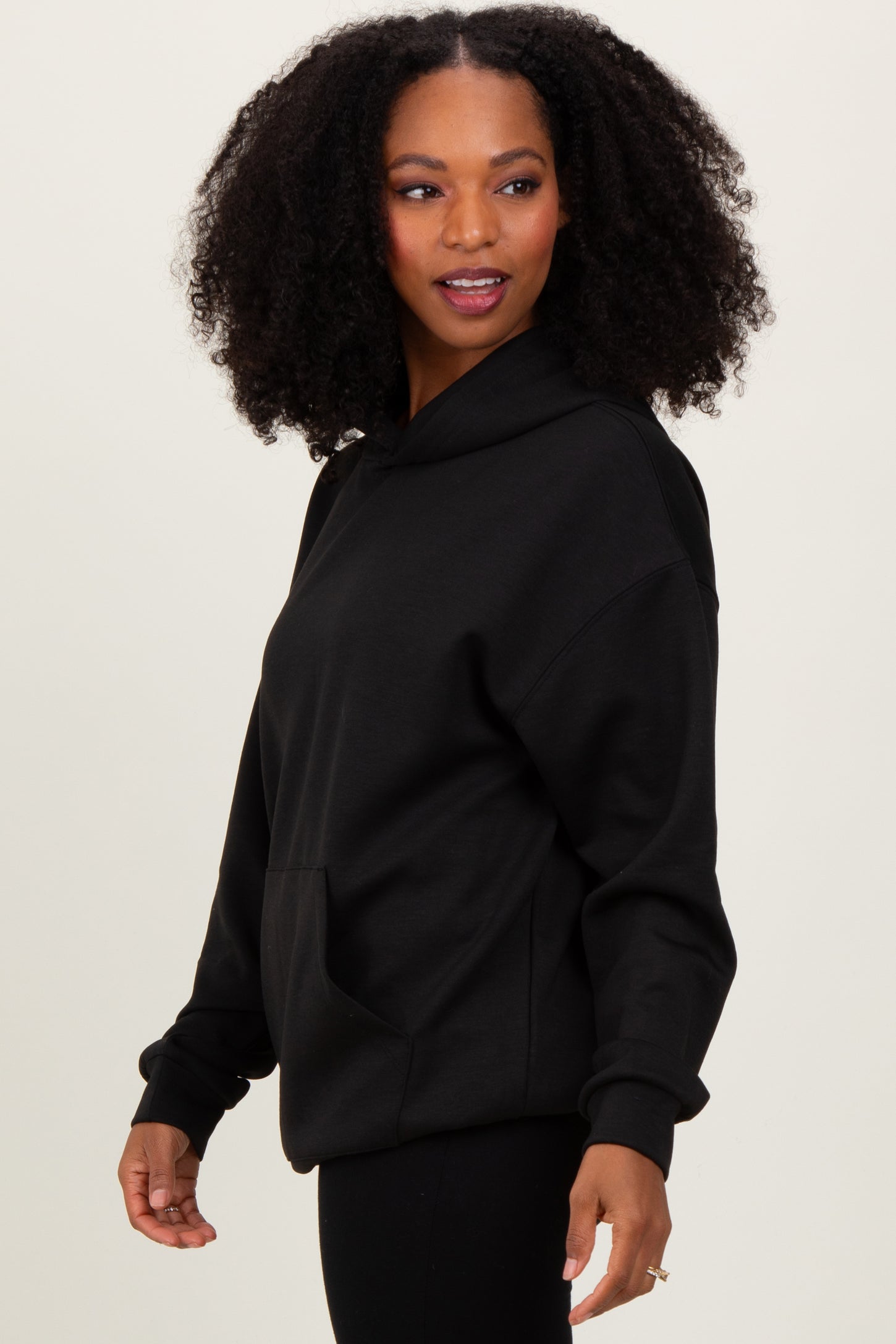 woman wearing a black oversized hoodie with a front pocket and relaxed fit