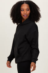 woman wearing a black oversized hoodie with a front pocket and relaxed fit