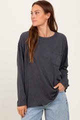 woman wearing a dark gray long sleeve t-shirt with a pocket and relaxed fit, styled with light blue jeans