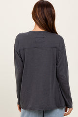 woman wearing a charcoal gray long sleeve top with a relaxed fit and back patch detail