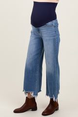 maternity wear, light wash denim wide leg jeans with a navy belly panel and frayed hem, model wearing brown ankle boots