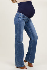 woman wearing a pair of blue maternity bootcut jeans with a navy belly panel and visible baby bump