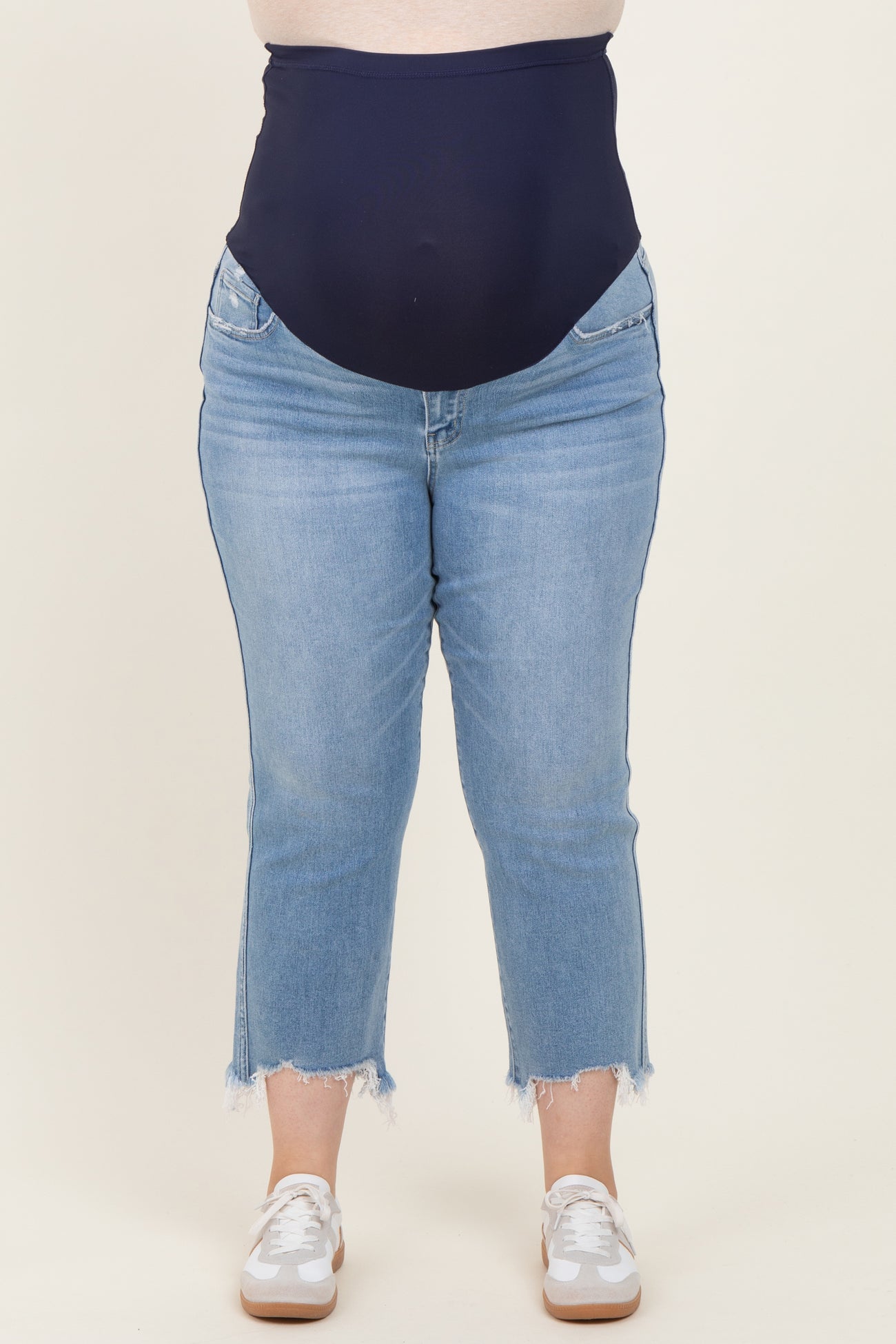 maternity plus high-waisted blue jeans with a stretchy panel for support, styled with frayed hem and worn with white sneakers