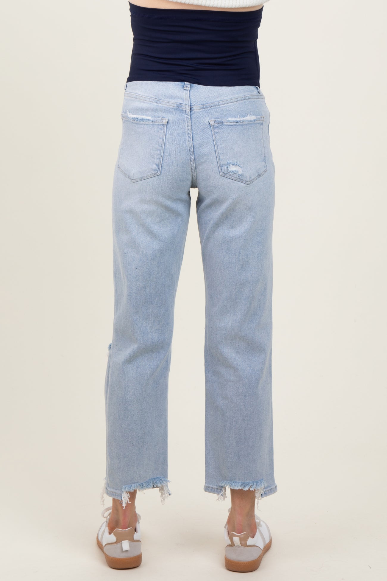 maternity wear light blue distressed straight leg jeans with frayed hem, shown from the back