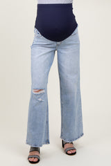 woman wearing light blue distressed maternity jeans with a navy blue over-the-bump waistband