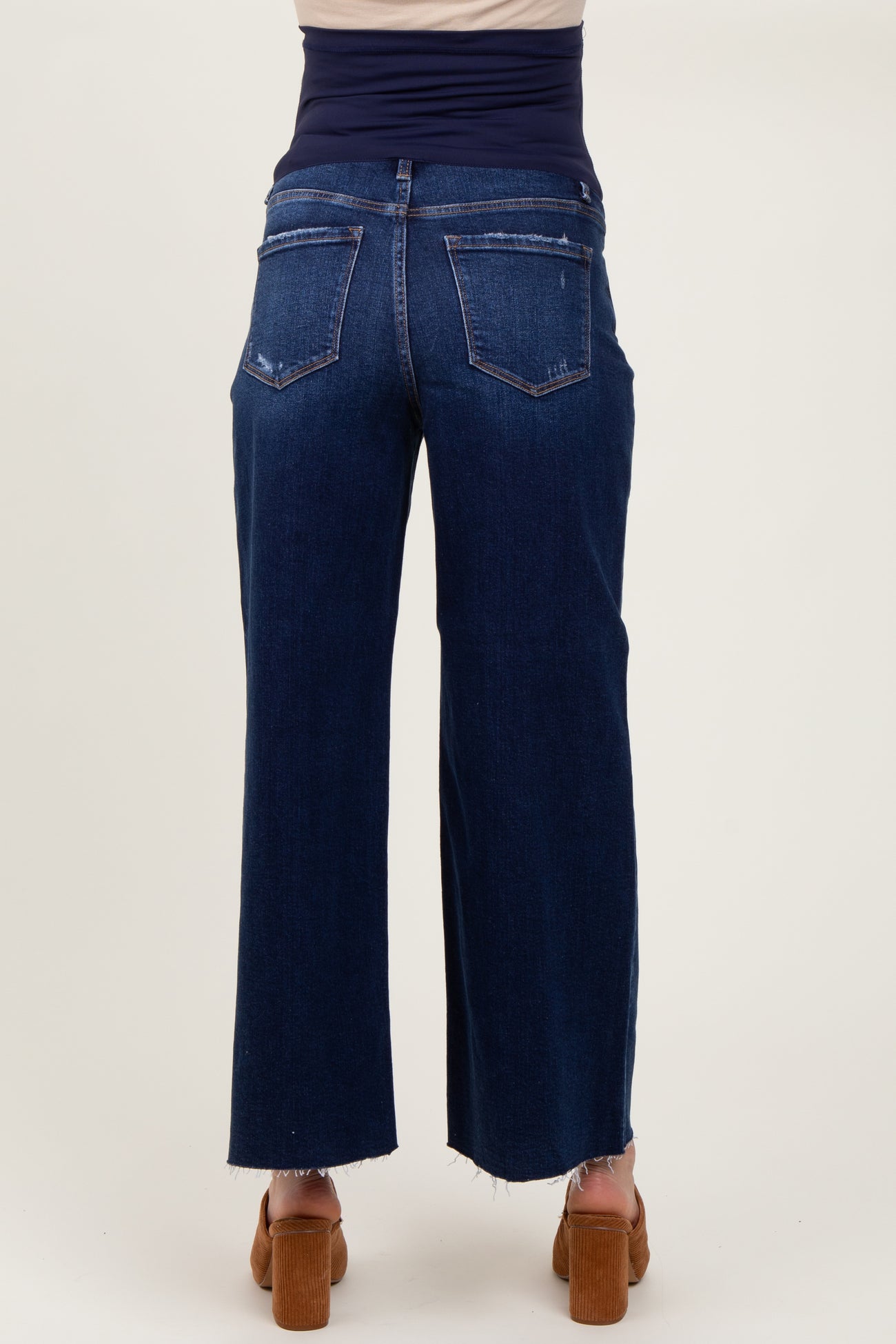 woman wearing dark blue maternity jeans with a high waistband and a relaxed fit, shown from the back