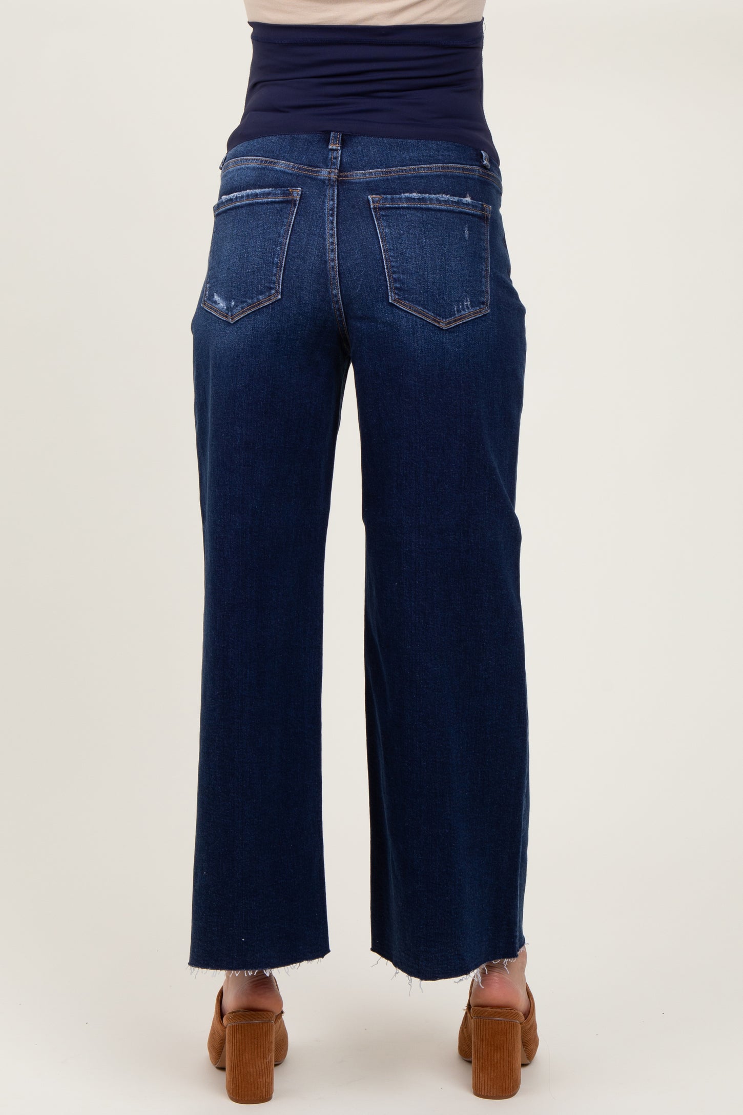woman wearing dark blue maternity jeans with a high waistband and a relaxed fit, shown from the back
