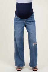 woman wearing maternity light blue wide-leg ripped jeans with a navy blue belly support band