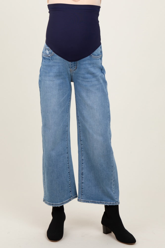 maternity wear featuring light wash wide-leg jeans with a navy blue over-the-bump panel, styled with black ankle boots