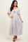 woman wearing a white floral maxi dress with short puff sleeves and a front tie detail