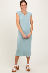 woman wearing a light blue ribbed midi dress with cap sleeves and side slit, smiling with hands on her hips