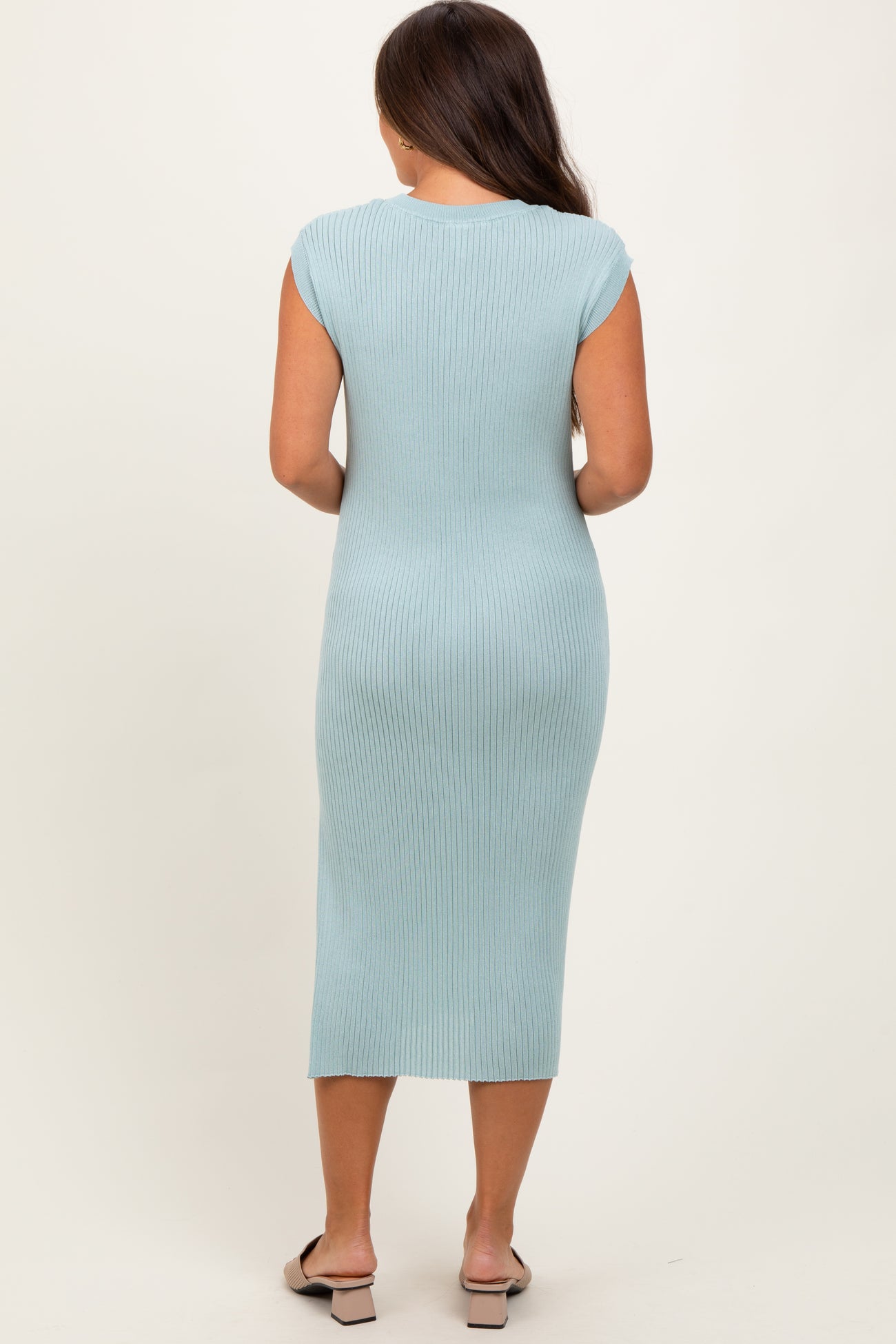 woman wearing a light blue ribbed maternity midi dress, showing a fitted silhouette from the back
