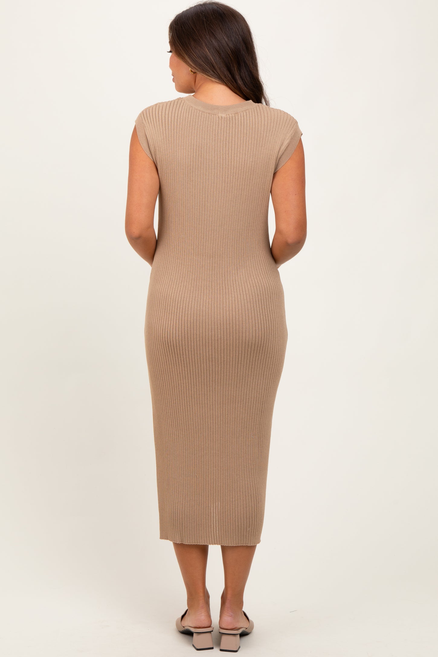 woman wearing a beige ribbed maternity dress, fitted style, visible baby bump, seen from the back