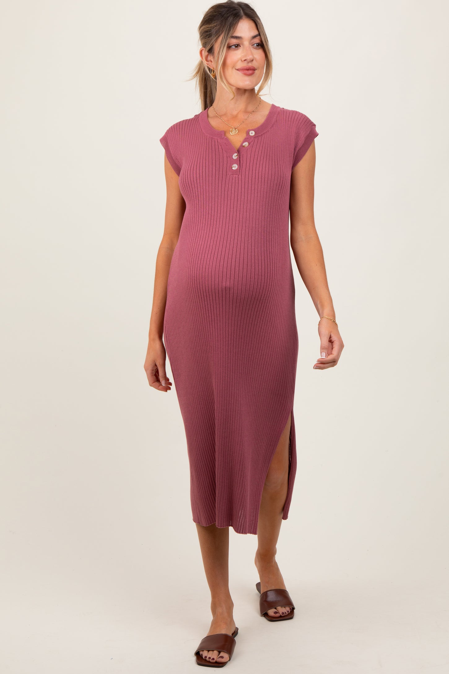 woman wearing a rose ribbed maternity dress with cap sleeves and side slits, showcasing her baby bump