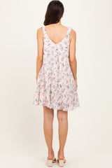 woman wearing a floral patterned sleeveless sundress with ruffled straps and a flared skirt