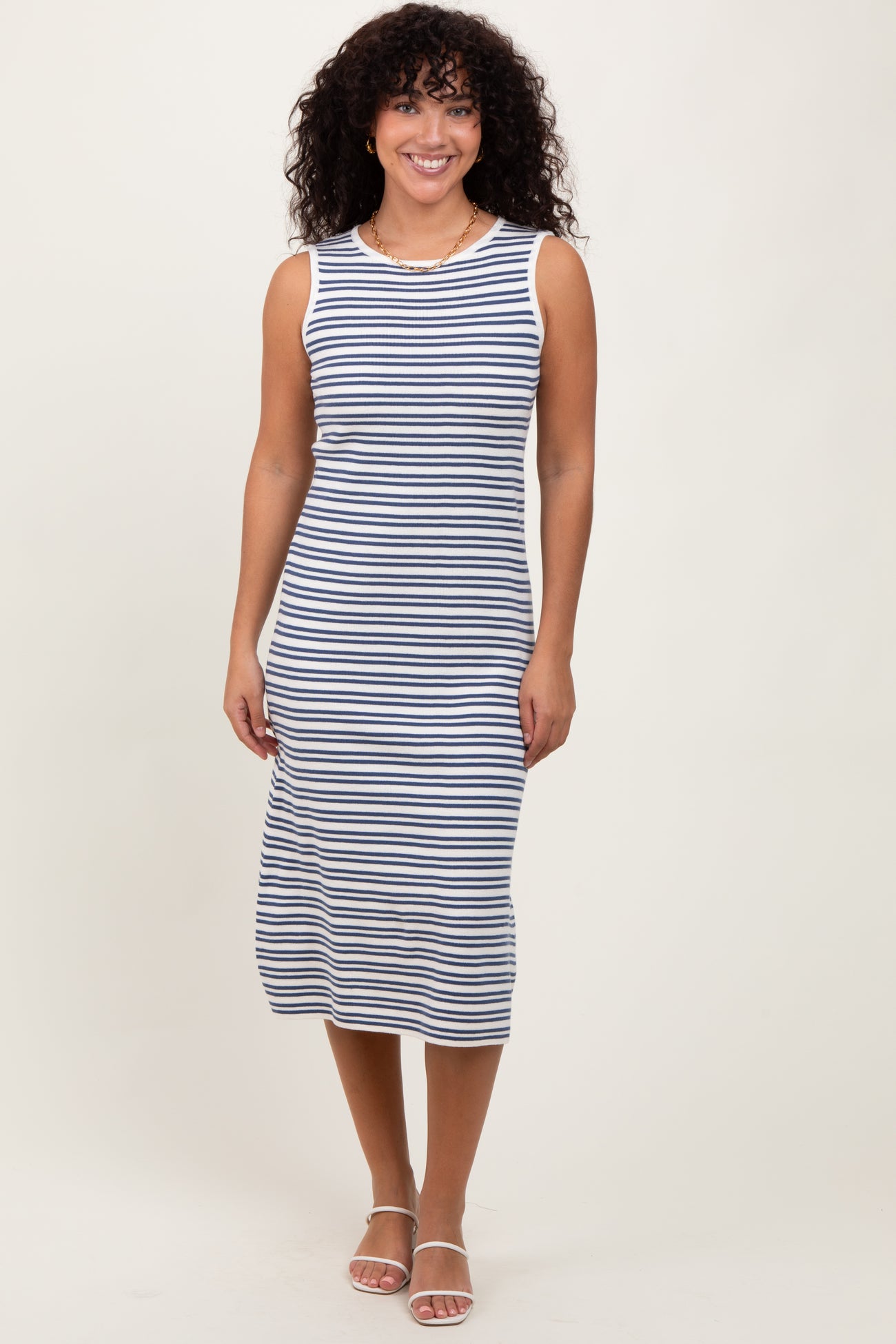 woman wearing a navy and white striped sleeveless midi dress with a fitted silhouette