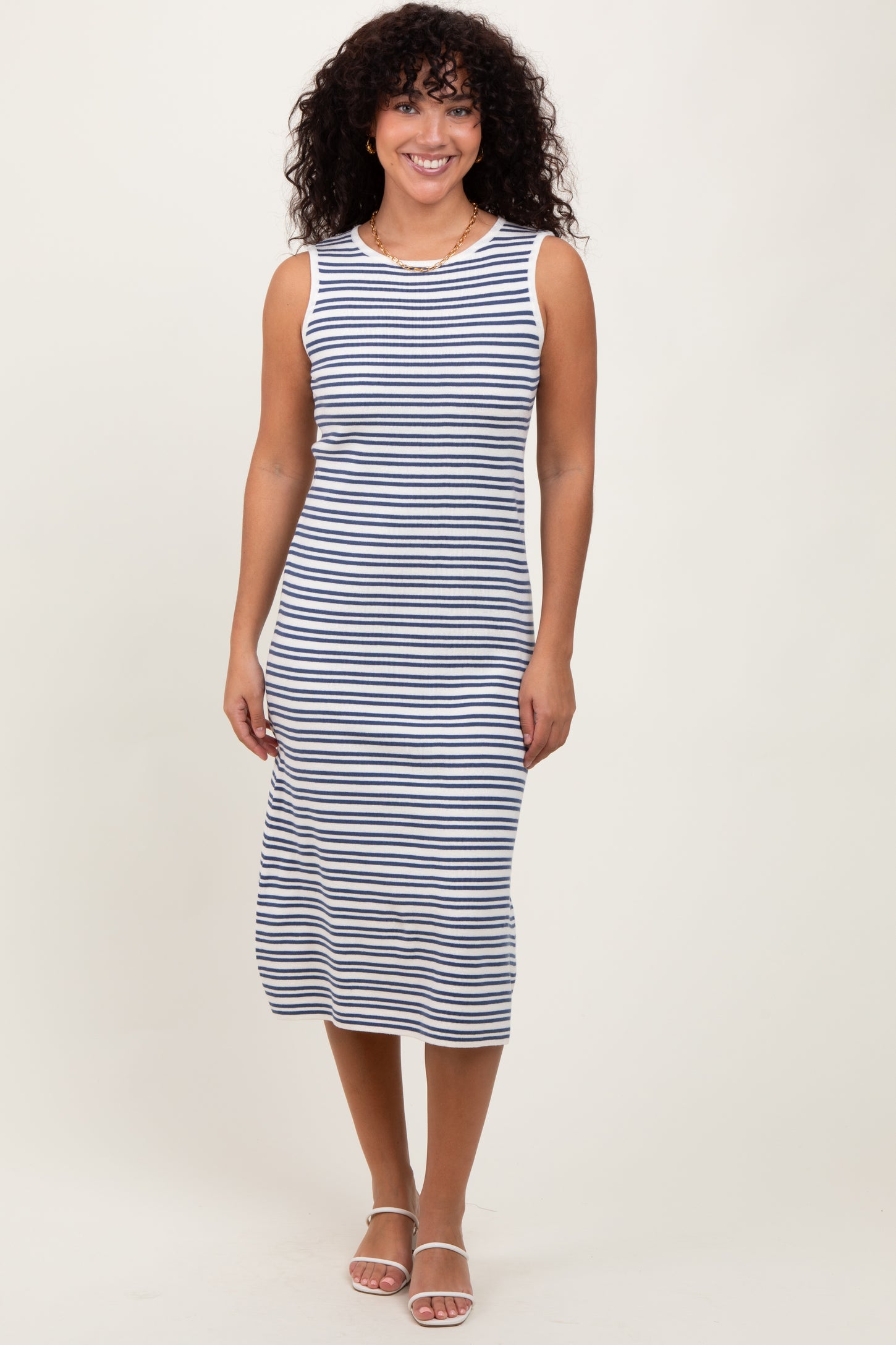 woman wearing a navy and white striped sleeveless midi dress with a fitted silhouette
