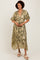 woman wearing a green floral print maxi dress with short sleeves and a deep v-neck, standing and smiling