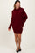 woman wearing a burgundy oversized sweater dress with long sleeves and a cowl neckline