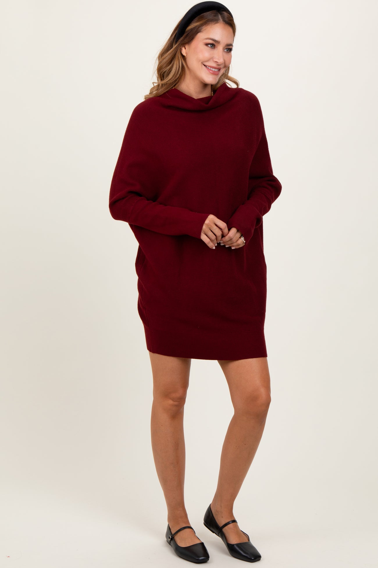 woman wearing a burgundy oversized hoodie dress with a cowl neck and long sleeves