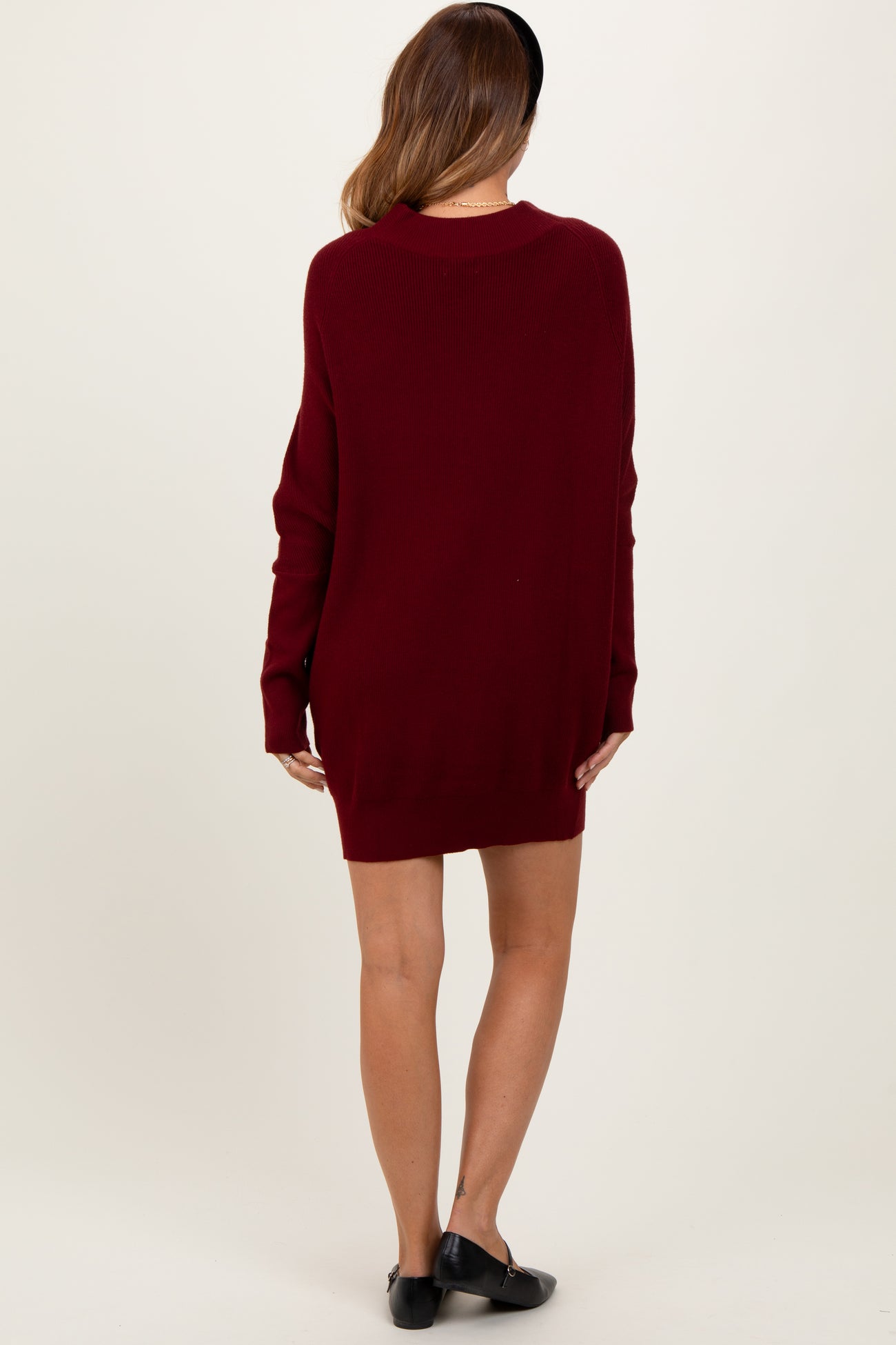 woman wearing a burgundy oversized sweater dress with long sleeves and a relaxed fit from the back