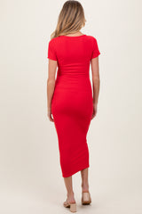 woman wearing a red short sleeve maternity dress with a fitted silhouette and midi length