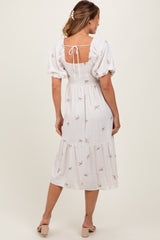 woman wearing a white midi dress with puff sleeves and a back tie detail, featuring a sweet bow print