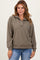 woman wearing a taupe quilted pullover sweater with a collar and long sleeves, paired with blue jeans