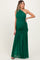 woman wearing a dark green one-shoulder maternity maxi dress with ruching and a flowy bottom, showcasing her baby bump