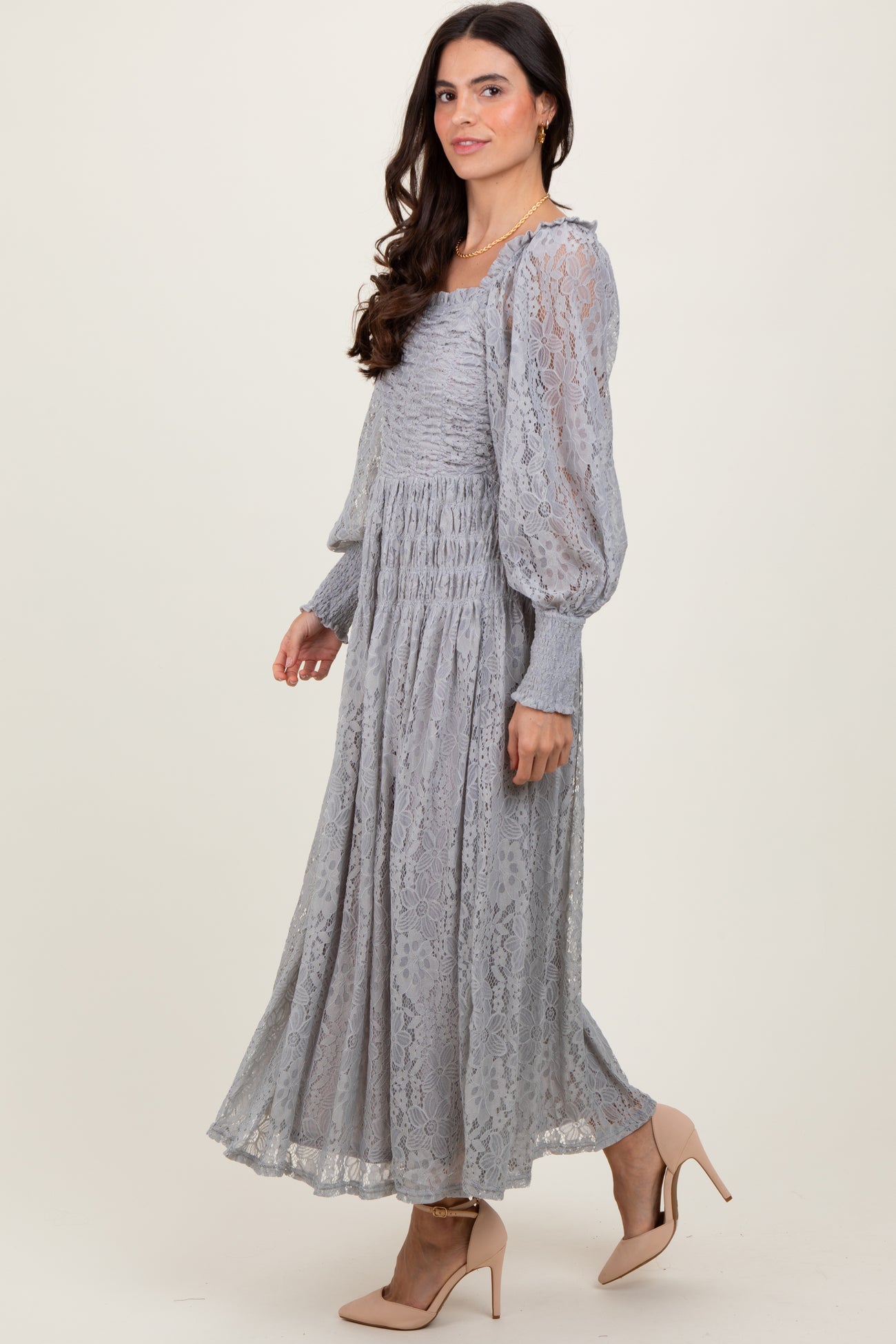 woman wearing a light gray long sleeve lace maxi dress with puff sleeves and a cinched waist