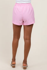 woman wearing soft pink striped shorts with an elastic waistband and side pockets, showing the back view