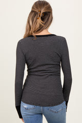 woman wearing a black and white striped maternity long sleeve top with a fitted style and back view showing a baby bump