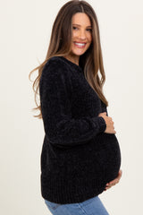 woman wearing a black cozy maternity sweater and holding her baby bump