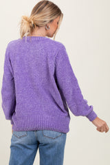 woman wearing a purple oversized sweater with ribbed details and casual jeans, viewed from the back
