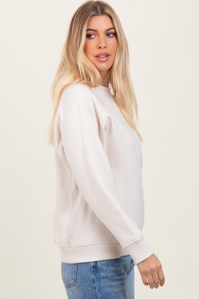 woman wearing a cream long sleeve sweatshirt with ribbed side panels and casual style