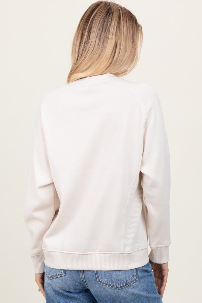 woman wearing a cream long sleeve sweatshirt with a relaxed fit and ribbed hem, shown from the back