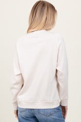 woman wearing a cream long sleeve sweatshirt with a relaxed fit and ribbed hem, shown from the back