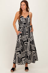 woman wearing a black and white geometric print maxi dress with pockets and a tie waist