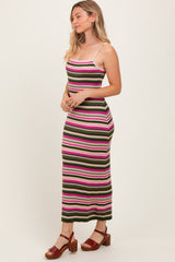 woman wearing a fitted striped maxi dress in pink, green, and white with spaghetti straps and side slits