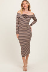woman wearing a brown and beige striped off-shoulder midi dress with a rose detail on the chest