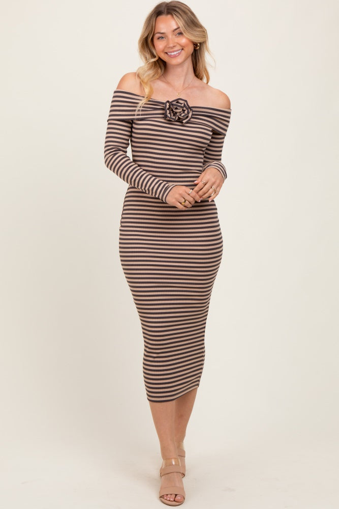 woman wearing a brown and cream striped off-the-shoulder dress with a rose detail on the front