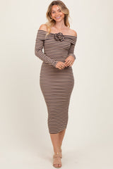 woman wearing a brown and cream striped off-the-shoulder dress with a rose detail on the front
