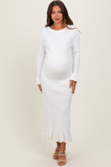 woman wearing a white ribbed maternity dress with long sleeves and frill hem, showing baby bump
