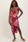 woman wearing a pink and red abstract print midi dress with ruched detailing and thin straps